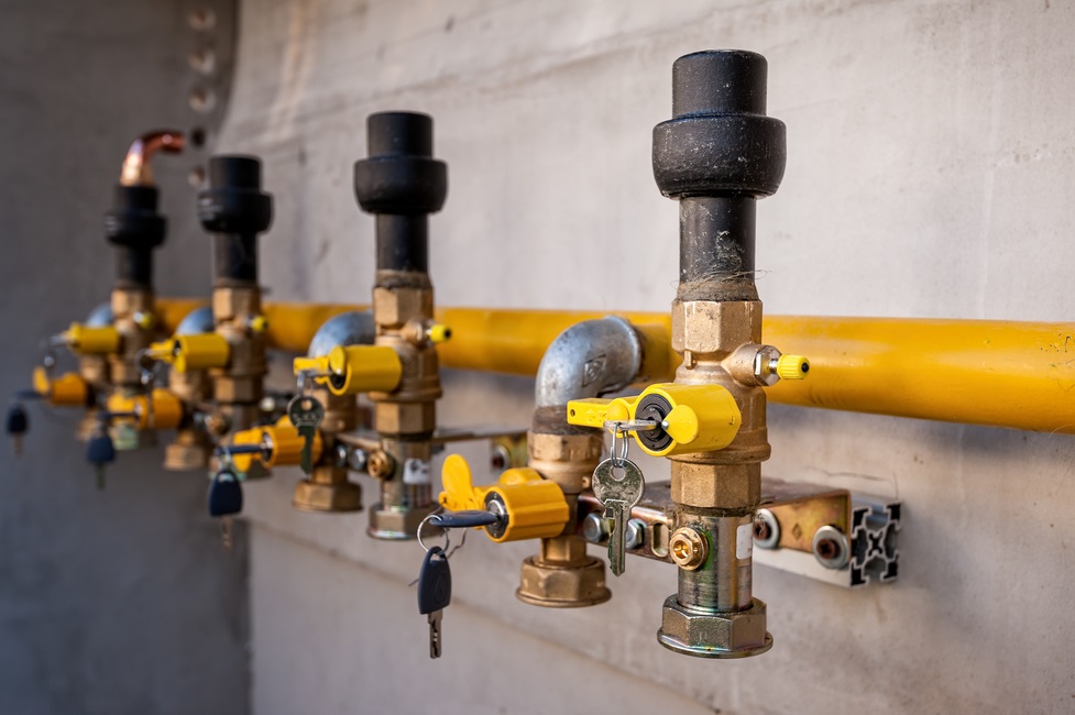 Gas pipe and valve with lock on the wall.